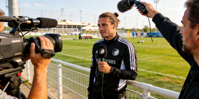 足球运动员在训练场接受媒体采访的瞬间